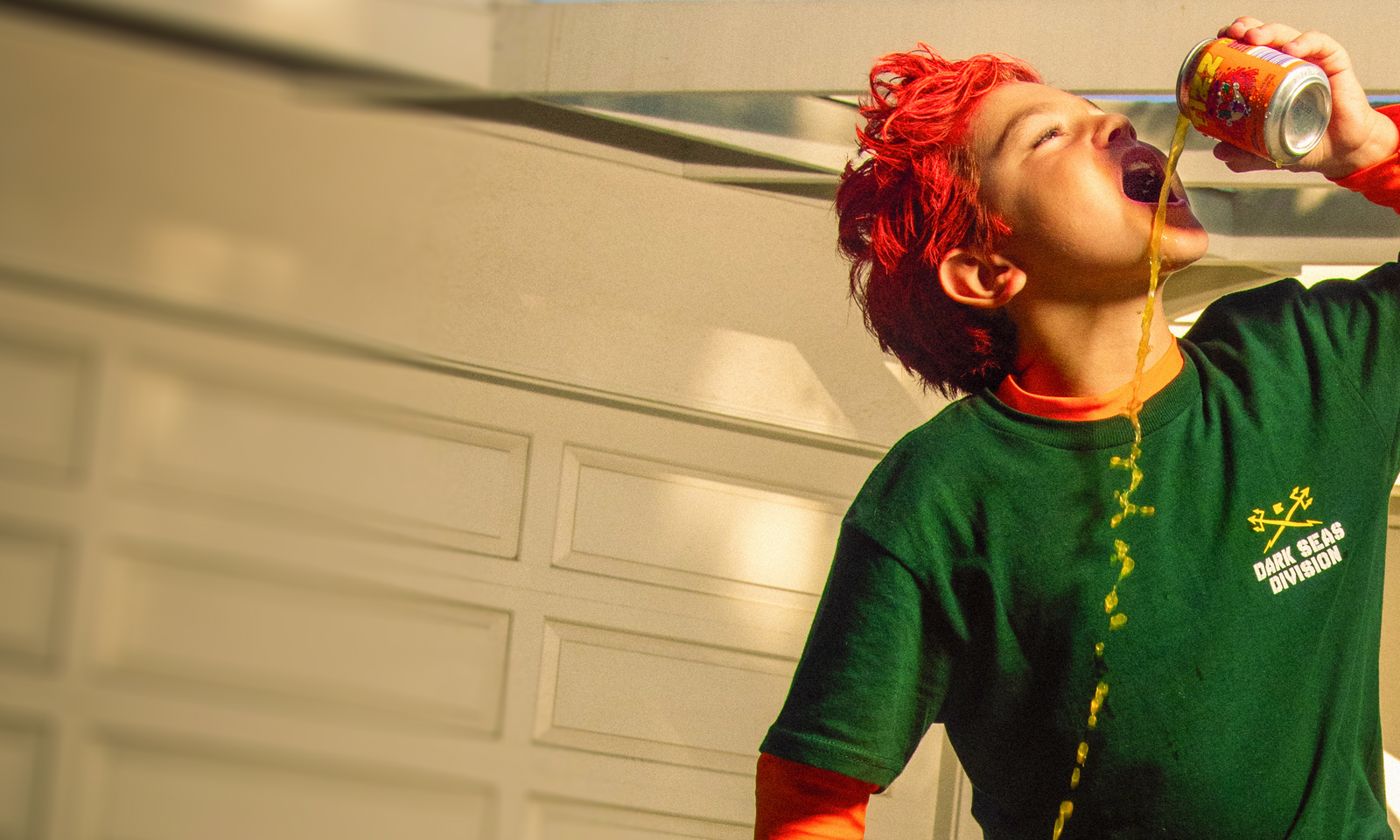 Red-haired kid chugging a can of TIZZ with orange soda spilling down his chin